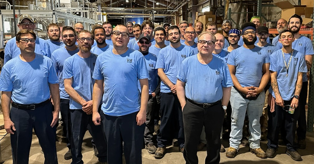 Members of UE Local 319 wearing blue union t-shirts in the shop