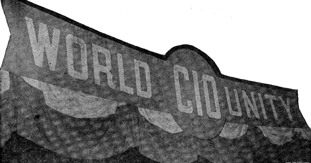 Black and white newspaper photo of a banner reading World Unity with CIO in the middle