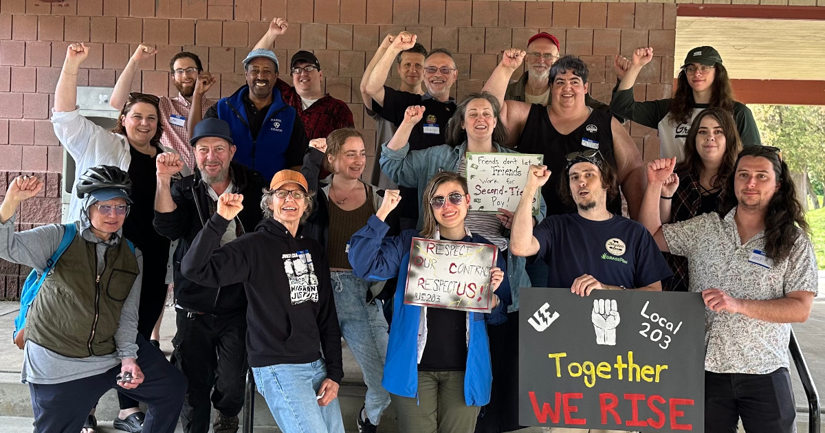 UE Local 203 members at a picnic shelter with raised fists