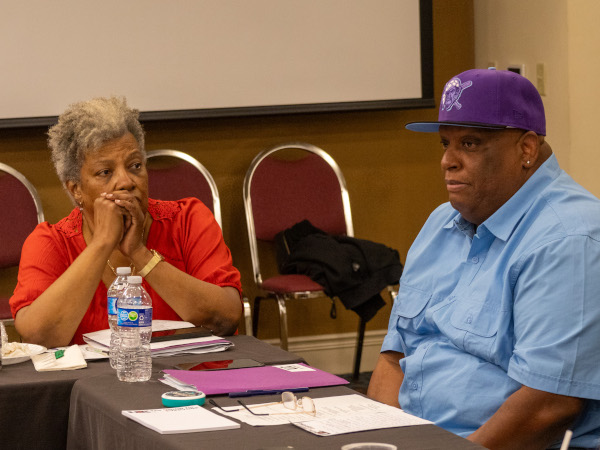 Delores Phillips and Larry Hopkins sitting at the corner of a conference table
